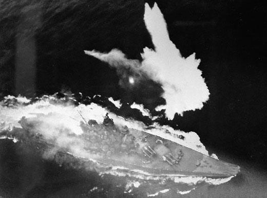 Yamato under angreb. Der er en stor brand agten for overbygningen, skibet synker senere efter skader fra et torpedotræf.